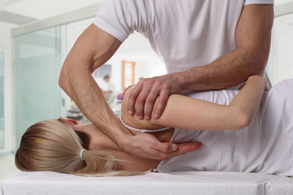 Woman having chiropractic back adjustment